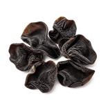 A small natural cluster of dried black fungus with dark brown-black curled lobes on a pure white background.