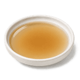 Clear light-amber Chinese cooking wine in a low warm off-white ceramic condiment dish on a pure white background.