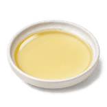 Clear pale straw-yellow cooking oil in a low warm off-white ceramic condiment dish on a pure white background.